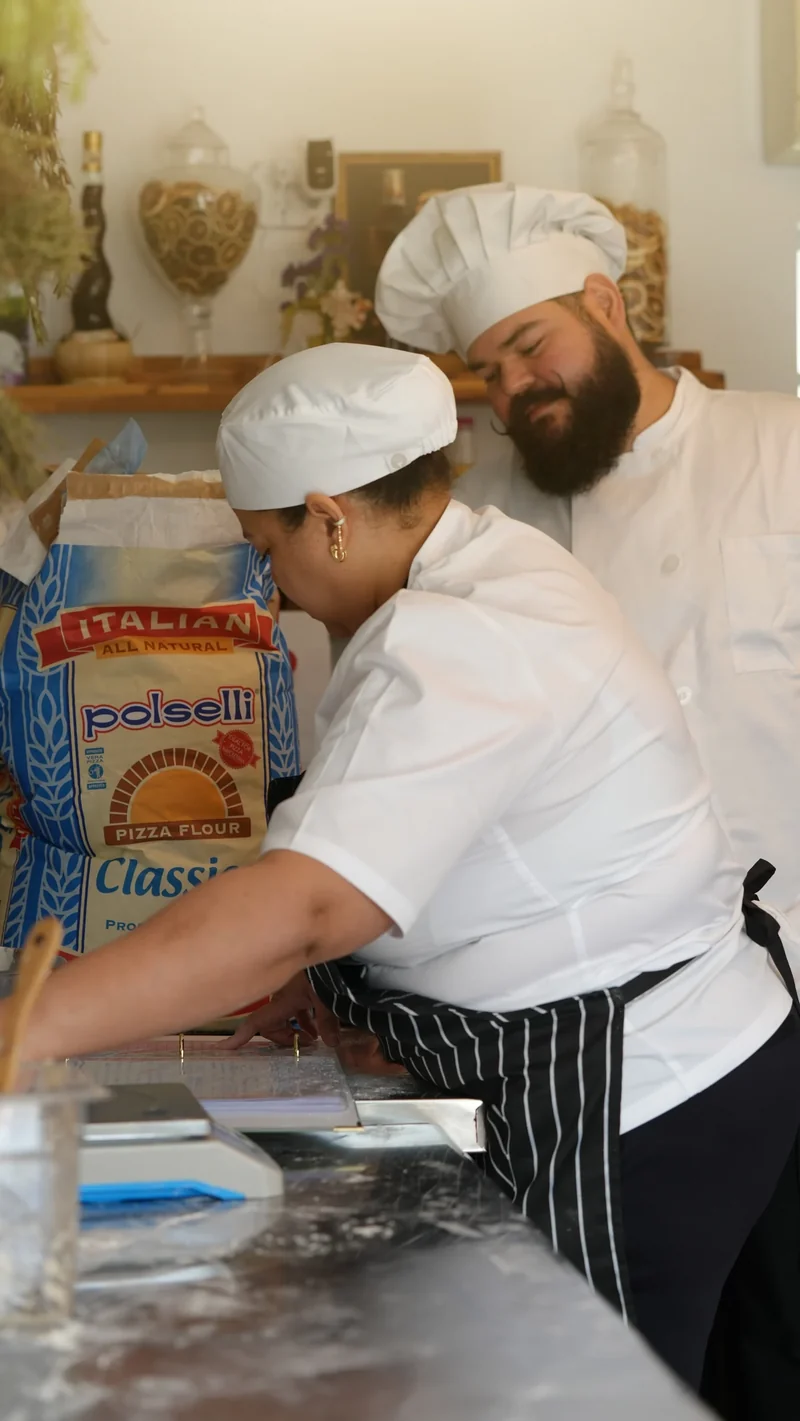 Maison Q bakery team preparing dough by hand in the kitchen.
