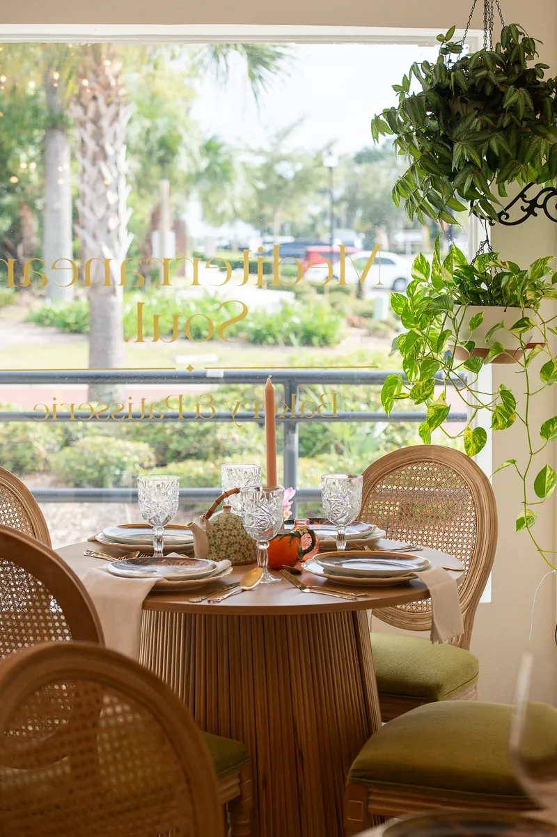 A table set with porcelain and glassware beside the Maison Q window.