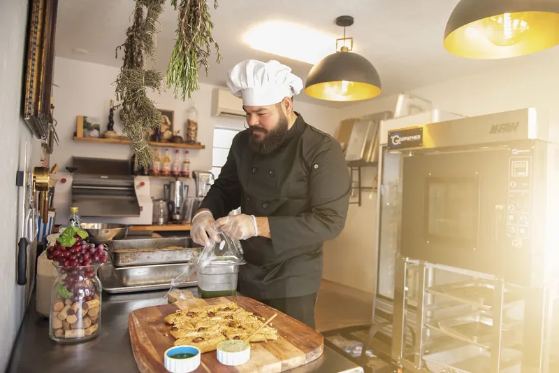 Chef preparing food in the Maison Q kitchen.