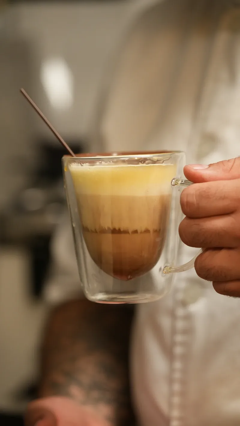 A layered latte served in a clear glass.