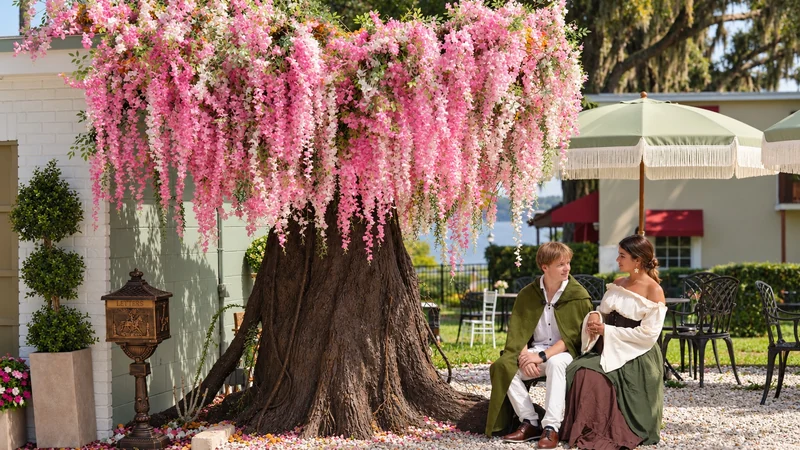 Guests sharing a quiet moment beneath Maison Q’s flowering tree in Downtown Clermont, Florida.